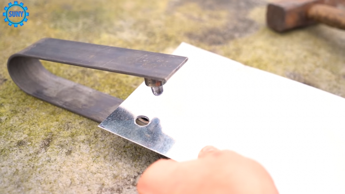 Het proces van het maken van gaten in de metaalplaat met een zelfgemaakte instrument